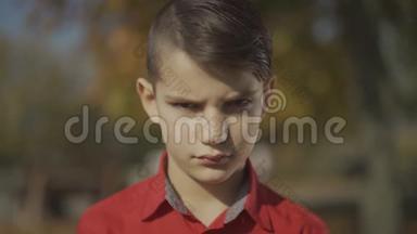 一个小男孩的肖像，<strong>先</strong>是悲伤，然后是微笑。 穿红色衬衫的可<strong>爱</strong>孩子花时间在户外。 悲伤